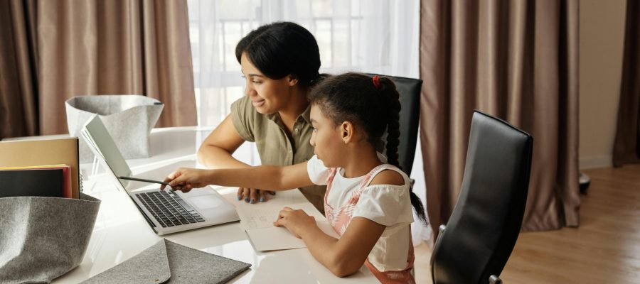 pexels-photo-4260323-4260323 A mother assisting her daughter with online learning on a laptop, promoting education and family bonding.